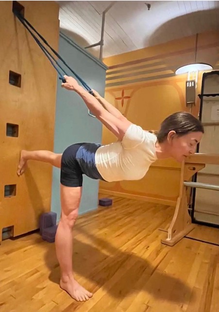 Image of a woman doing yoga using a yoga wall